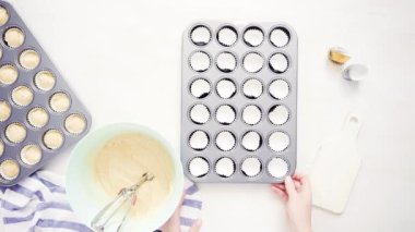 Düz yatıyordu. Cupcake gömlekleri içine vanilyalı kek hamuru scooping.