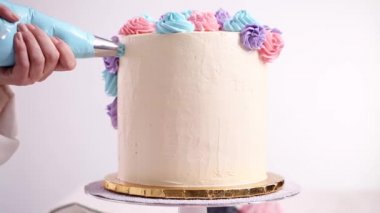 Baker boru pastel renk buttercream rozet beyaz bir pastayı tek boynuzlu at yapmak kek.