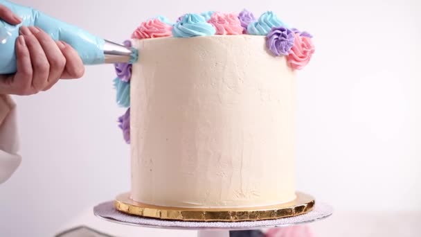 贝克管道柔和的颜色蝴蝶奶油玫瑰在一个白色的蛋糕 使独角兽蛋糕 — 图库视频影像