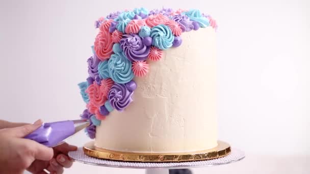 Bäcker Piping Pastell Farbe Buttercreme Rosetten Auf Einem Weißen Kuchen — Stockvideo