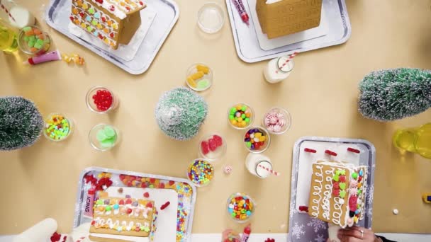 クリスマスに飾る小さなジンジャーブレッドの家子供クラフト パーティー — ストック動画