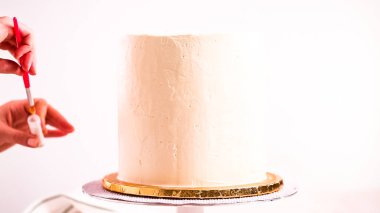 Bir tek boynuzlu at yapmak için beyaz bir pasta yemek glitter uygulama Baker'ın pasta.