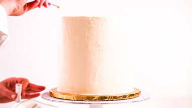 Bir tek boynuzlu at yapmak için beyaz bir pasta yemek glitter uygulama Baker'ın pasta.