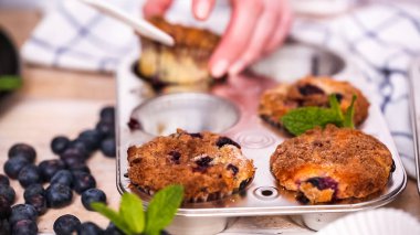 Blueberry muffins metal muffin pan dışarı alarak.
