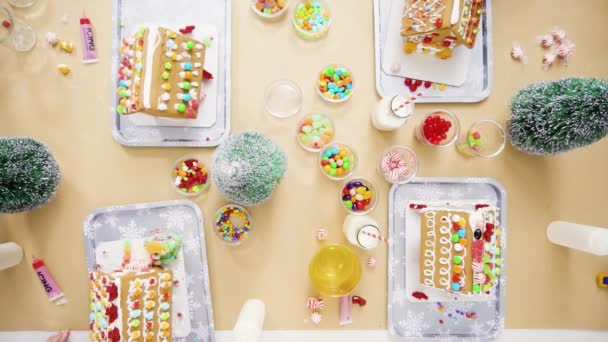 平躺着 一步一步 孩子们在圣诞工艺聚会上装饰小姜饼屋 — 图库视频影像