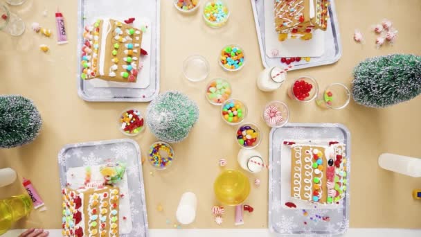 平躺着 一步一步 孩子们在圣诞工艺聚会上装饰小姜饼屋 — 图库视频影像