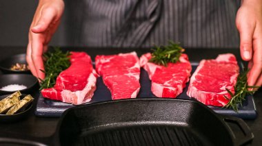 Dökme demir tavada ham New York şerit biftek.