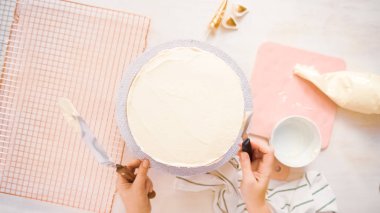Düz yatıyordu. Beyaz buttercream buzlanma ile pembe ve mor pasta buzlanma.