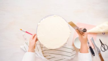 Düz yatıyordu. Beyaz buttercream buzlanma ile pembe ve mor pasta buzlanma.