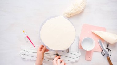 Düz yatıyordu. Beyaz buttercream buzlanma ile pembe ve mor pasta buzlanma.