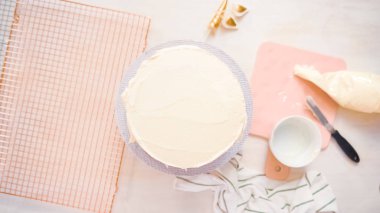 Düz yatıyordu. Beyaz buttercream buzlanma ile pembe ve mor pasta buzlanma.