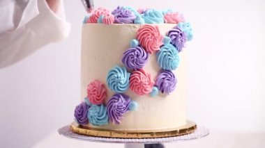 Baker boru pastel renk buttercream rozet beyaz bir pastayı tek boynuzlu at yapmak kek.