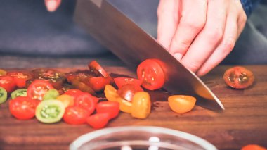 Adım adım. Hatıra cherry domates ahşap kesme tahtası üzerinde Dilimleme.