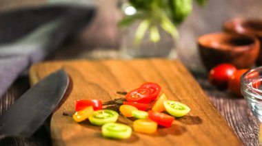 Adım adım. Hatıra cherry domates ahşap kesme tahtası üzerinde Dilimleme.