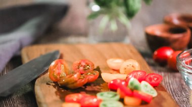 Adım adım. Hatıra cherry domates ahşap kesme tahtası üzerinde Dilimleme.