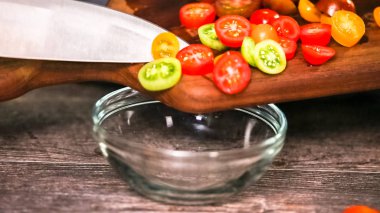 Adım adım. Hatıra cherry domates ahşap kesme tahtası üzerinde Dilimleme.