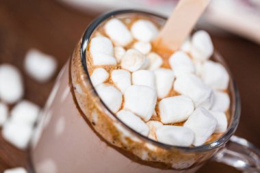 Yakın çekim. Tuzlu karamel sıcak kakao kaşık marshmallow ile tepesinde Cam Kupası.