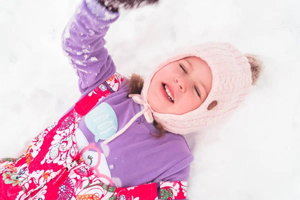 Karda Oynarken Pembe Şapkalı Küçük Kız — Stok fotoğraf