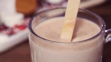 Ağır çekim. Yakın çekim. Tuzlu karamel sıcak kakao kaşık marshmallow ile tepesinde Cam Kupası.