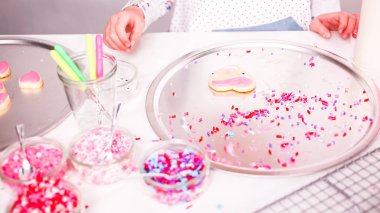 Adım adım. Küçük kız Kraliyet krema ve şeker ile şekerli kurabiye Sevgililer günü için decarting.