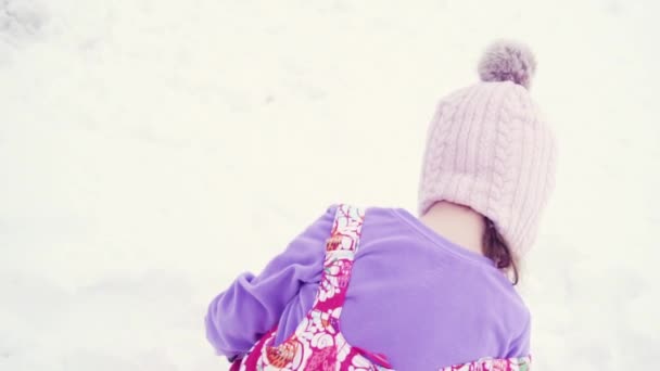 Slow Motion Klein Meisje Roze Hoed Spelen Sneeuw — Stockvideo