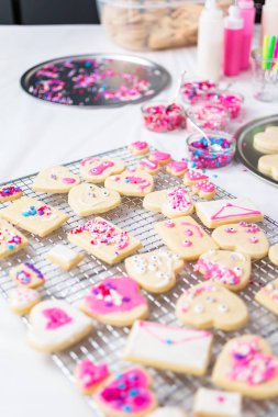 Sevgililer günü için kalp şekli şekerli kurabiye Kraliyet buzlanma ve pembe sprinkles ile dekorasyon.