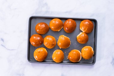 Tatlı çörek mini hamburger ekmeği bir fırın tepsisine.
