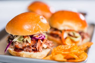Barbekü, brioche çörekleriyle küçük hamburgerler şeklinde domuz sandviçi çekti..