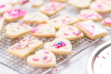 Sevgililer günü için kalp şekli şekerli kurabiye Kraliyet buzlanma ve pembe sprinkles ile dekorasyon.