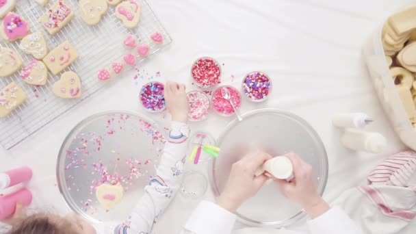 平躺着 一步一步 小女孩装饰与皇家糖霜和洒水的糖饼干情人节 — 图库视频影像