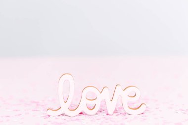 Pembe arka planda Sevgililer Günü Aşkı tabelası.