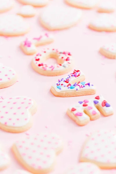砂糖のクッキーをバレンタインの日に高貴なアイシングで飾られたピンクの背景 — ストック写真