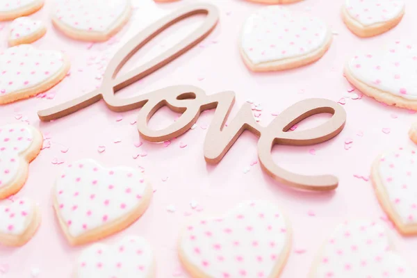 ピンクの背景のハート型シュガー クッキーと愛のサイン — ストック写真