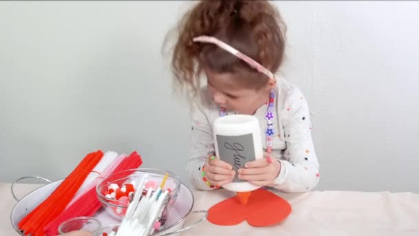 一歩一歩 バレンタインの日に紙の泡の中から工芸品を作る少女 — ストック動画