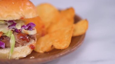 Barbekü, brioche çörekleriyle küçük hamburgerler şeklinde domuz sandviçi çekti..
