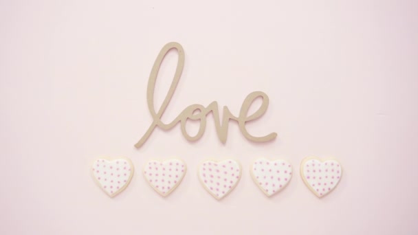 平躺着 心形糖饼干装饰与皇家糖霜情人节在粉红色的背景 — 图库视频影像