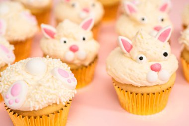 Pembe arka planda Paskalya tavşanı kekleri.