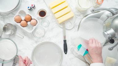 Adım adım. Düz yatıyordu. Üç katlı vanilyalı kek pişirmek için tereyağlı kek tavaları yağlamak..