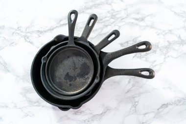 Mermer zemin üzerinde dökme demir tavaların çeşitliliği.