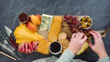 Düz yatıyordu. Büyük bir peynir tahtası için tahtanın üzerinde gurme peynir, kraker ve meyve düzenlemek.