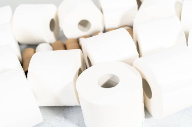 Gri arka planda yeni beyaz tuvalet kağıdı ruloları.