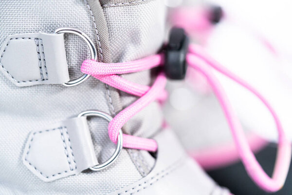 Закрывай. Маленькая девочка розовый и серый теплые и водонепроницаемые зимние сапоги на белом фоне.