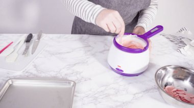 Adım adım. Çikolatalı şekerleri eritmek elektrikli bir şeker tenceresinde erir..