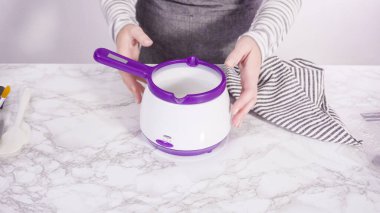 Adım adım. Çikolatalı şekerleri eritmek elektrikli bir şeker tenceresinde erir..