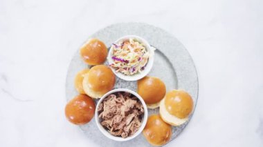 Barbekü, brioche çörekleriyle küçük hamburgerler şeklinde domuz sandviçi çekti..