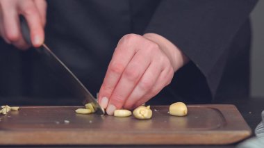 Adım adım. Ahşap kesme tahtası üzerinde küp şeklinde organik sarımsak.