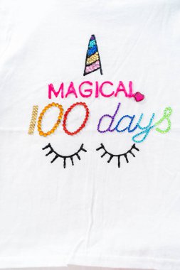 Düz yatıyordu. 100 günlük okul kutlaması için kız tişörtleri süslüyorsun..