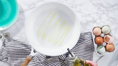 Düz yatıyordu. Beyaz tavada taze yumurta kızartıyorlar..