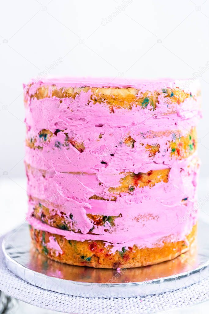 Funfetti cake layers with pink buttercream frosting.