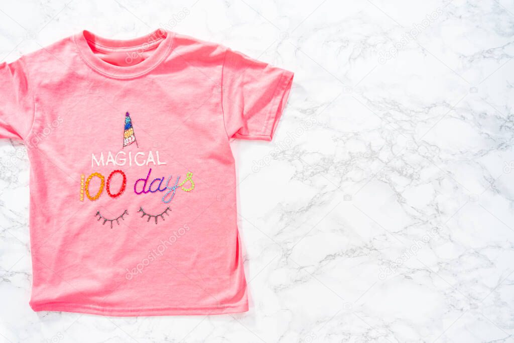 Flat lay. Decorating girl's t-shirts for 100 days of school celebration.